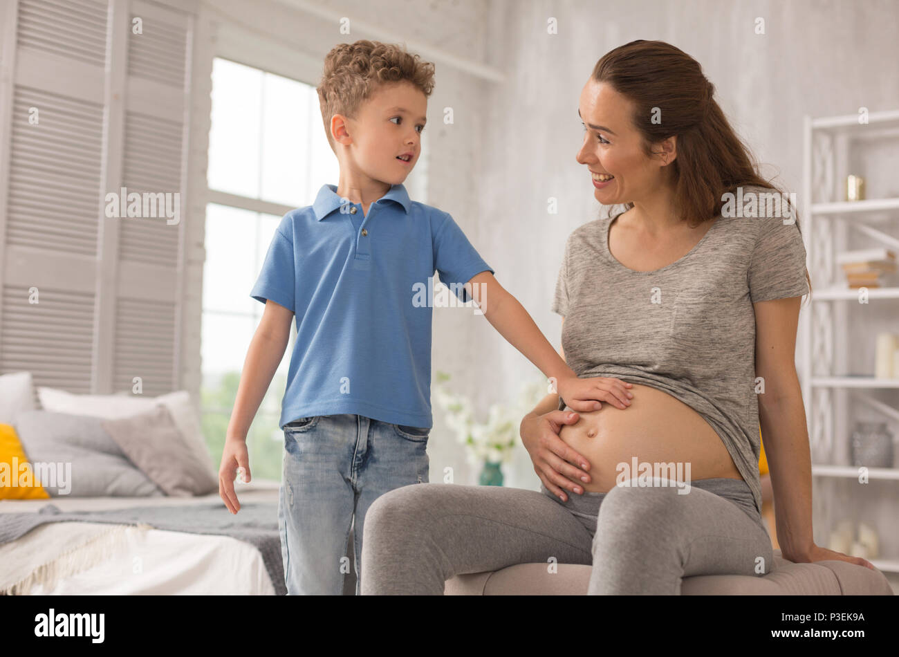 Appealing happy woman smiling broadly spending time with son Stock Photo