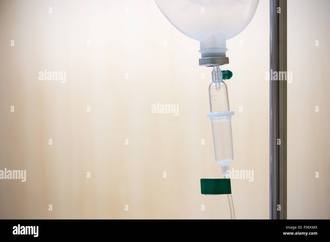 Close up saline solution drip for patient and infusion pump in hospital, with copy space wooden wall background at luxury VIP room. Stock Photo