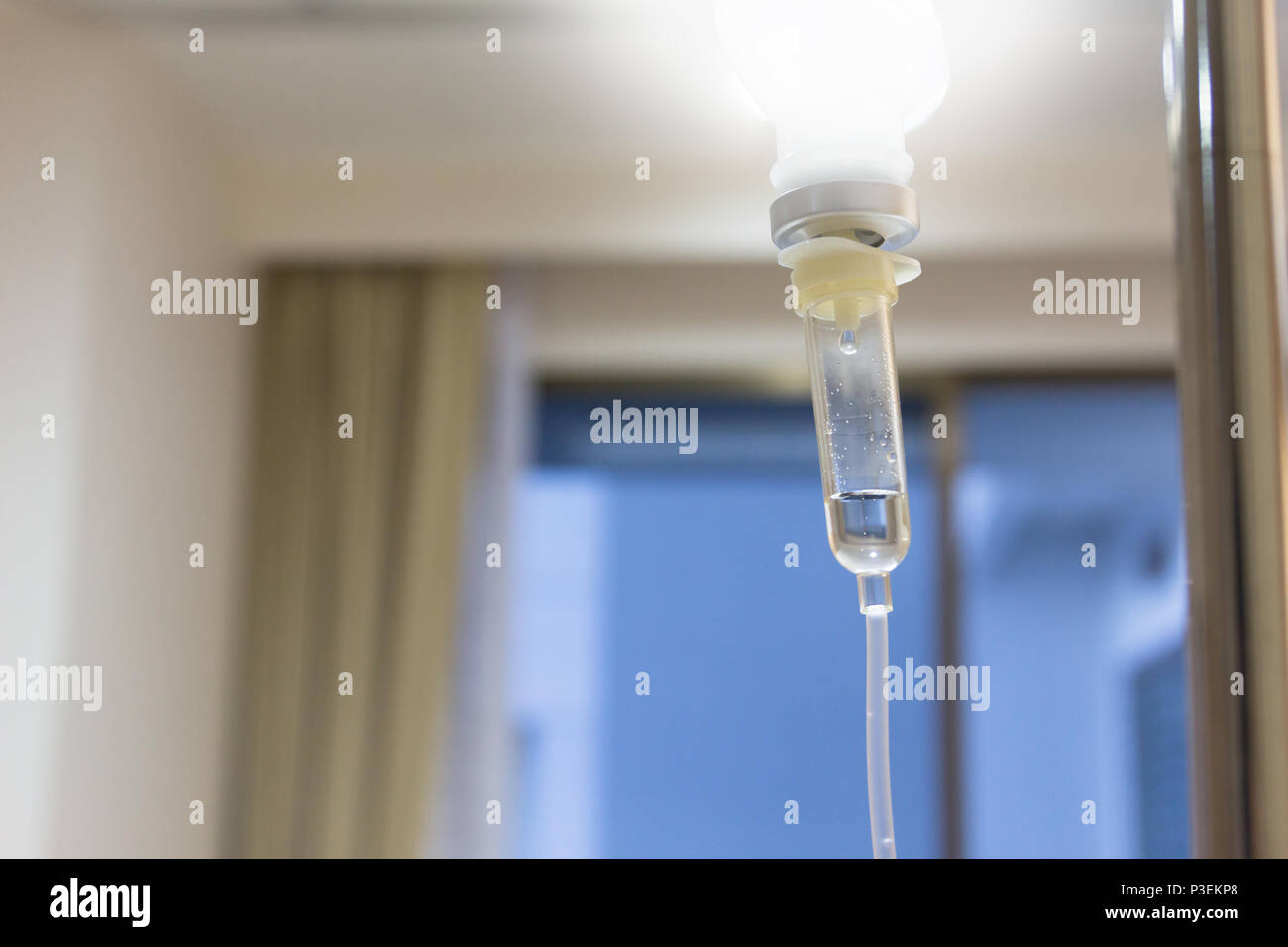 Close up saline solution drip for patient and infusion pump in hospital, with copy space window at luxury VIP room, effect light. Stock Photo