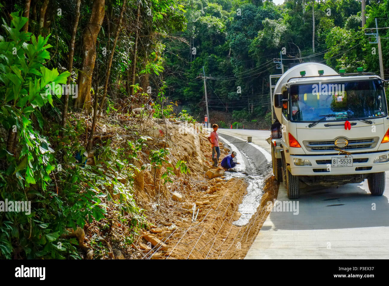 Construction Workers from Myanmar are building new roads through the jungles covering the mountains of the Thai island Koh Phangan, Thailand Stock Photo