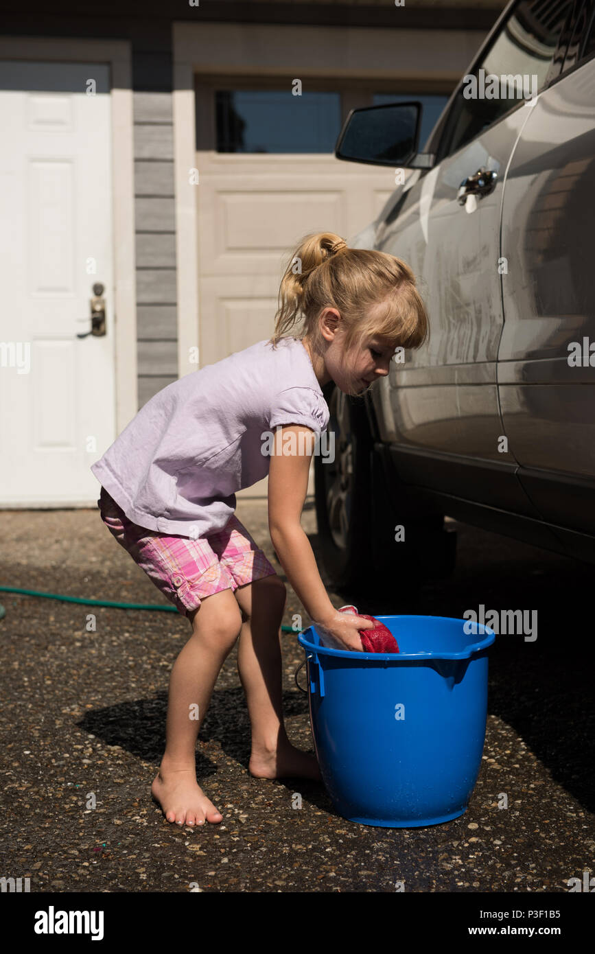 Girl washing a car at outside garage Stock Photo