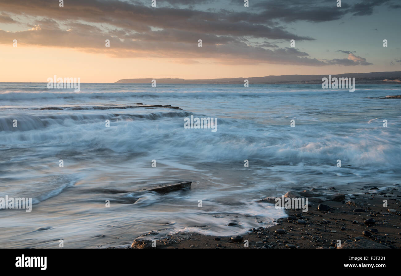 Dramatic beautiful sunset on a rocky coast. Long exposure photography Stock Photo