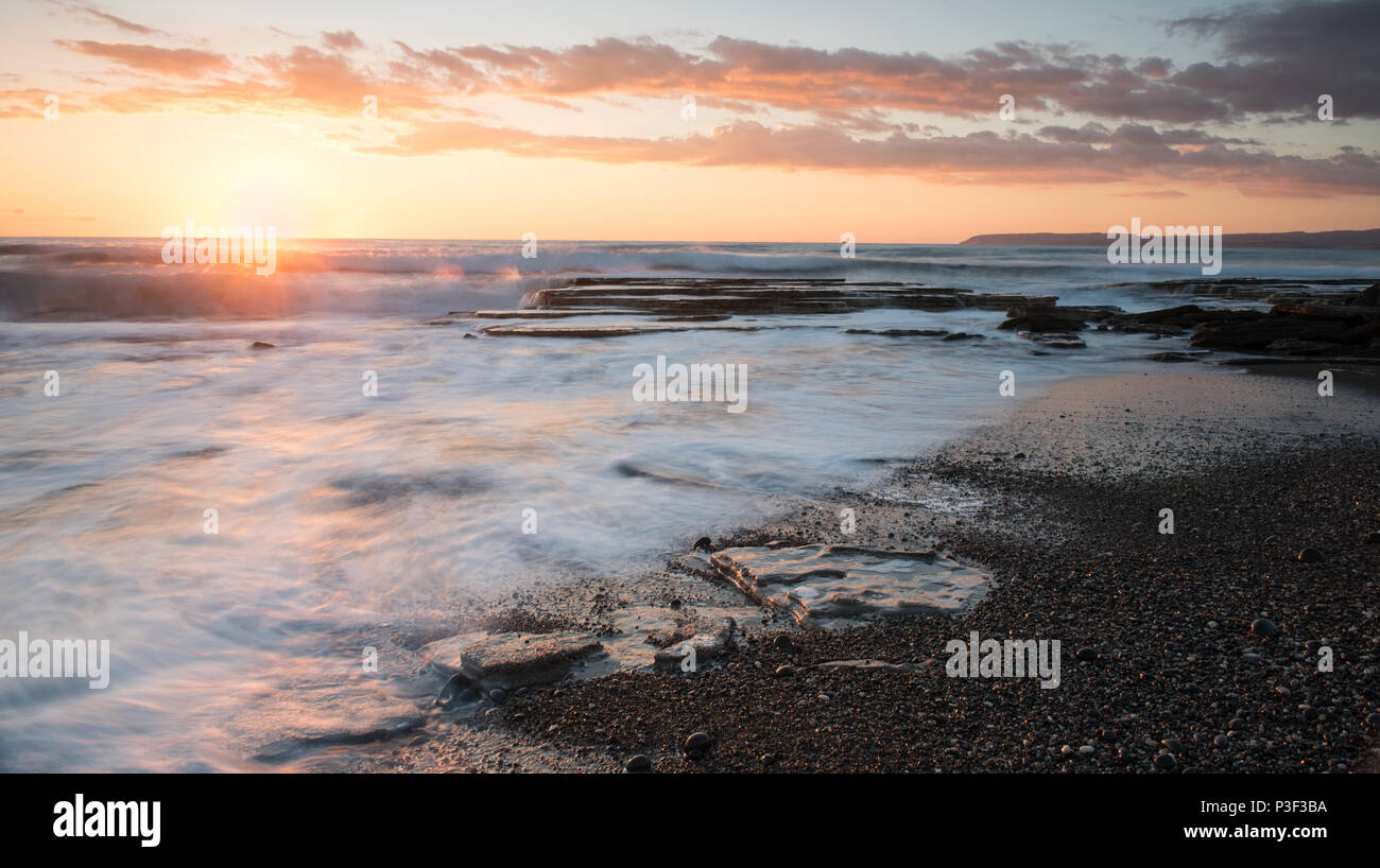 Dramatic beautiful sunset on a rocky coast at Akrotiri area in Limassol, Cyprus. Long exposure photography Stock Photo