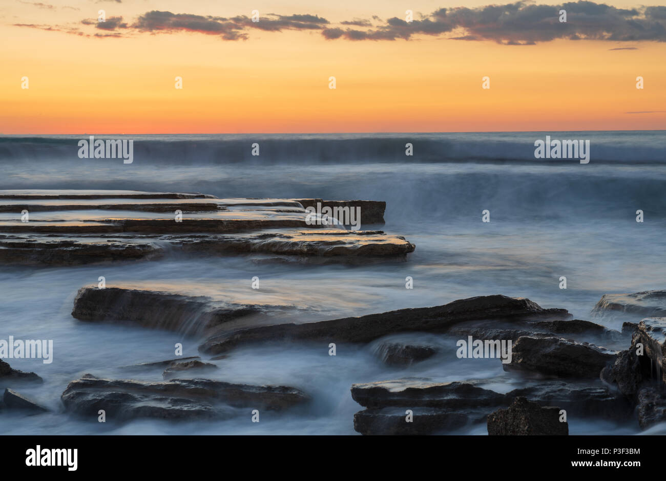 Dramatic beautiful sunset on a rocky coast at Akrotiri area in Limassol, Cyprus. Long exposure photography Stock Photo