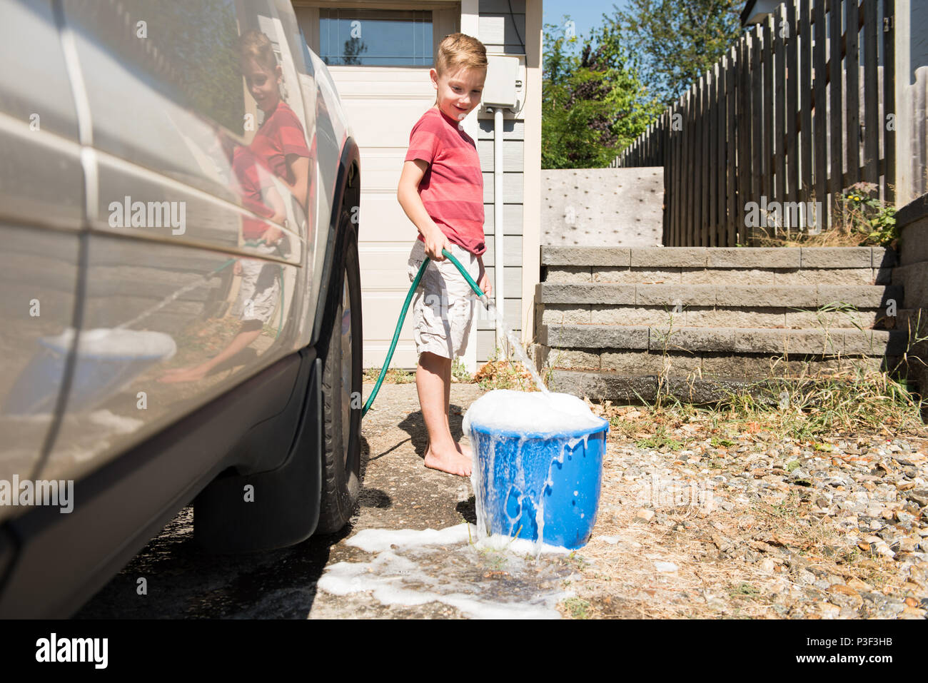 Boy filling bucket water in hires stock photography and images Alamy