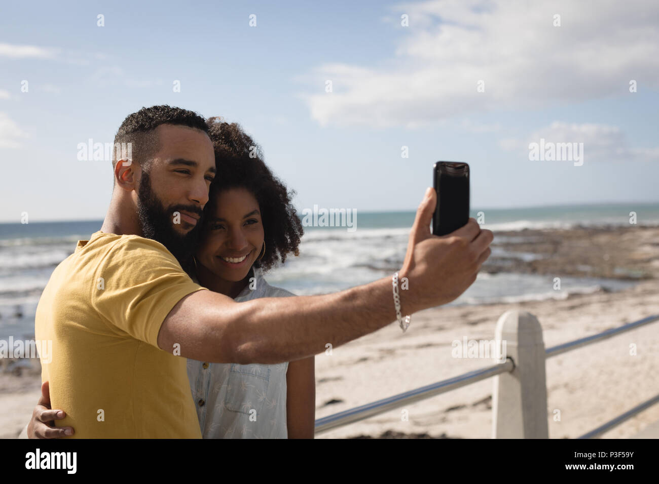 Couple taking selfie with mobile phone near beach Stock Photo