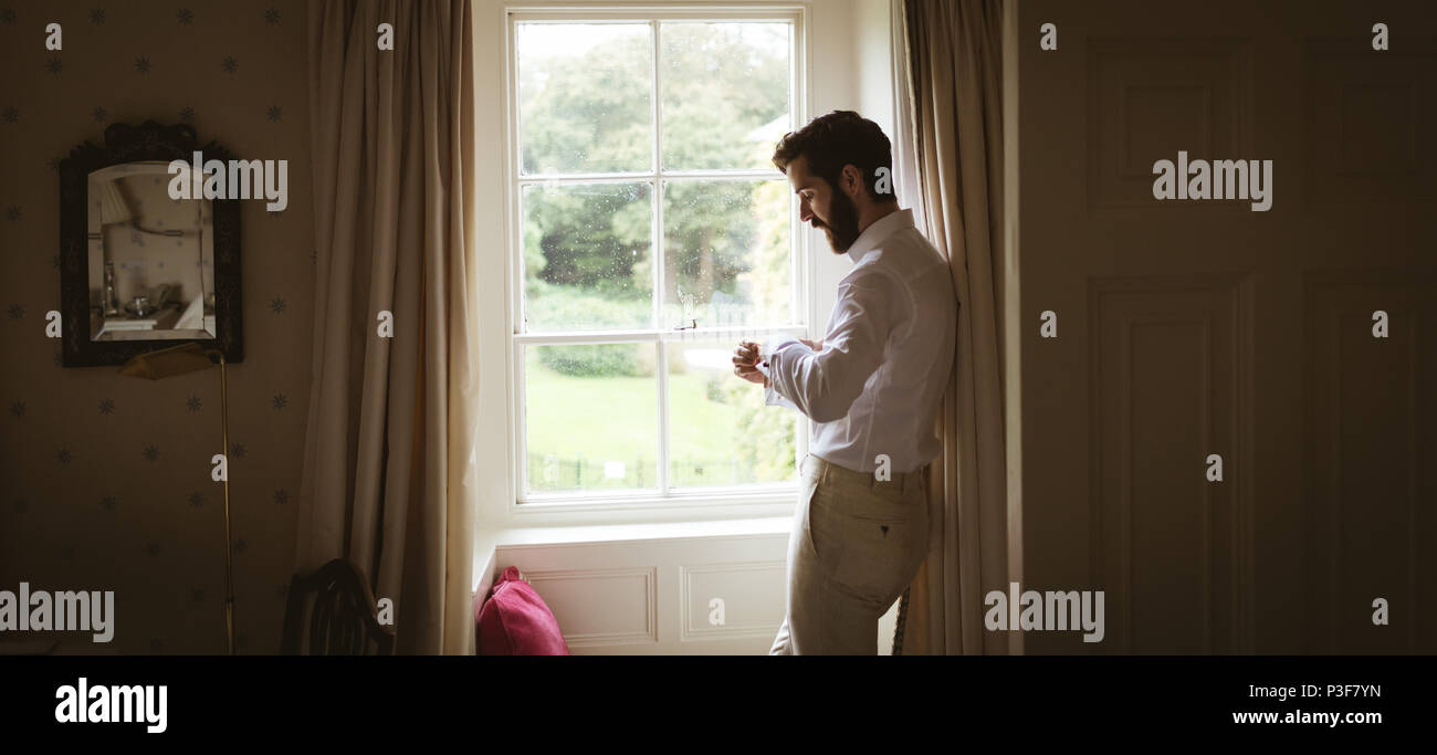 Man checking his watch near the window Stock Photo