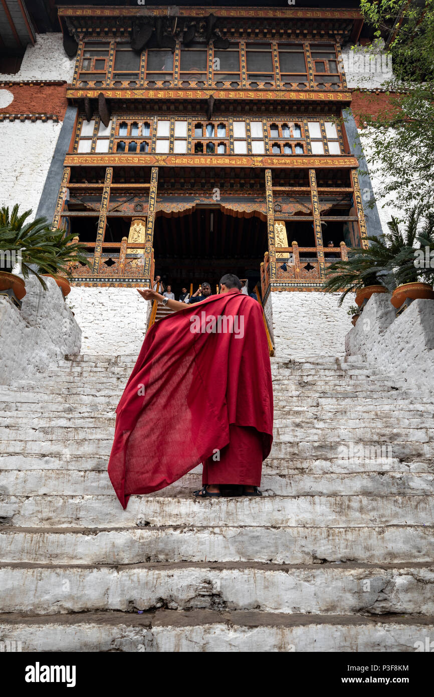 The beauty of Punakha Dzong is incomplete without its monks, drapped in red robe. Stock Photo