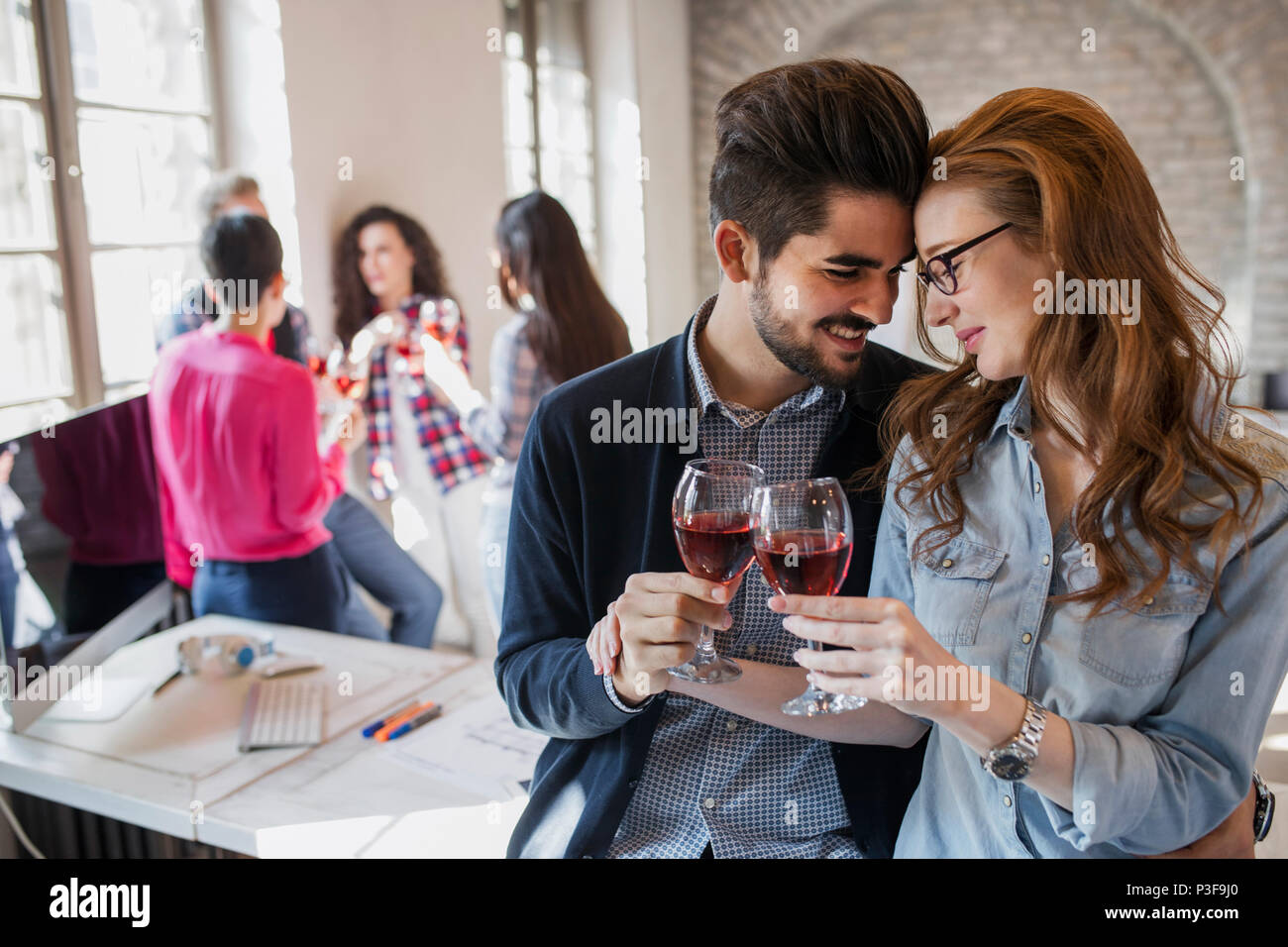 Happy young architects having break and drinking wine Stock Photo