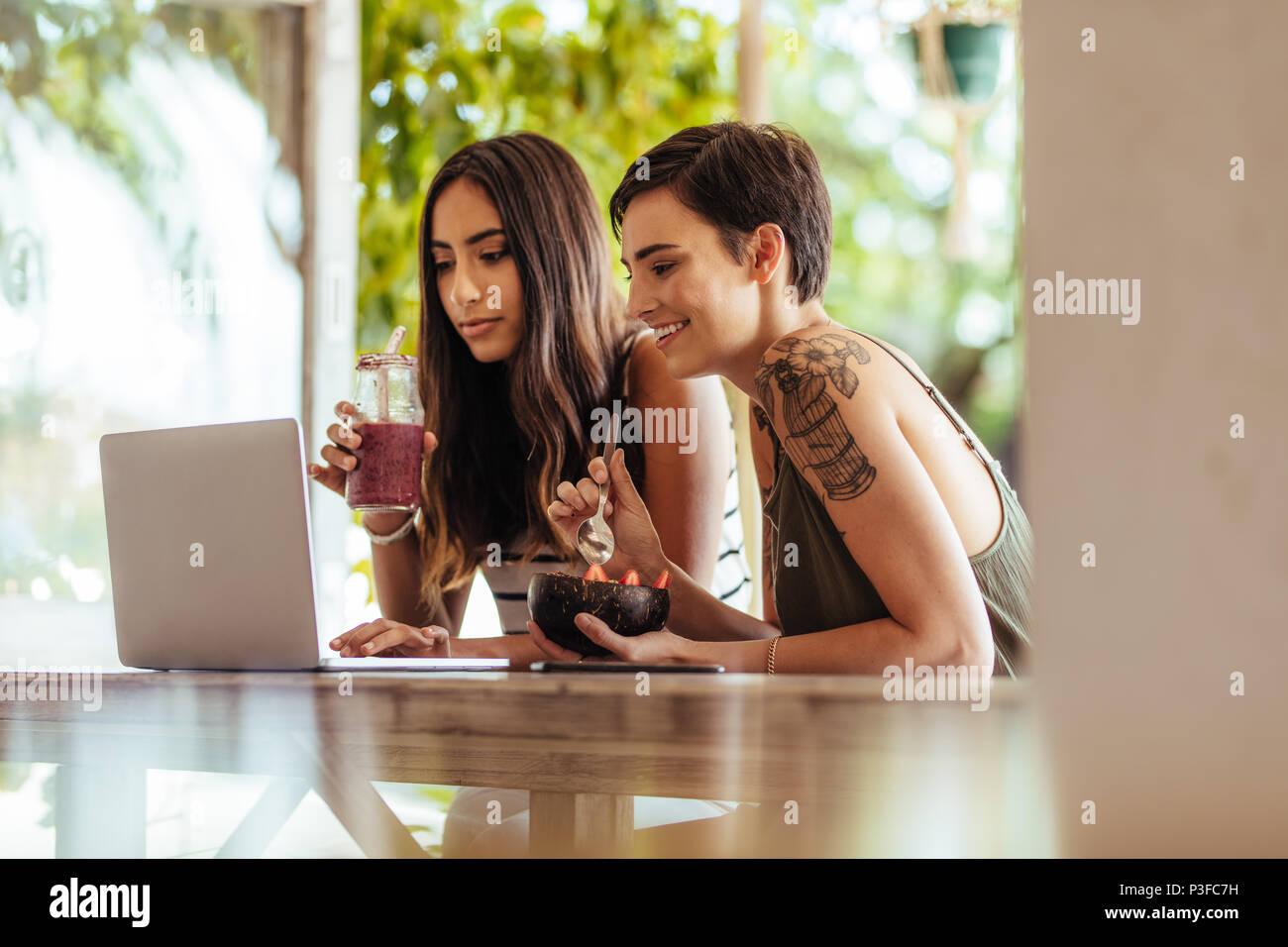 Two women sitting at a table hi-res stock photography and images - Alamy