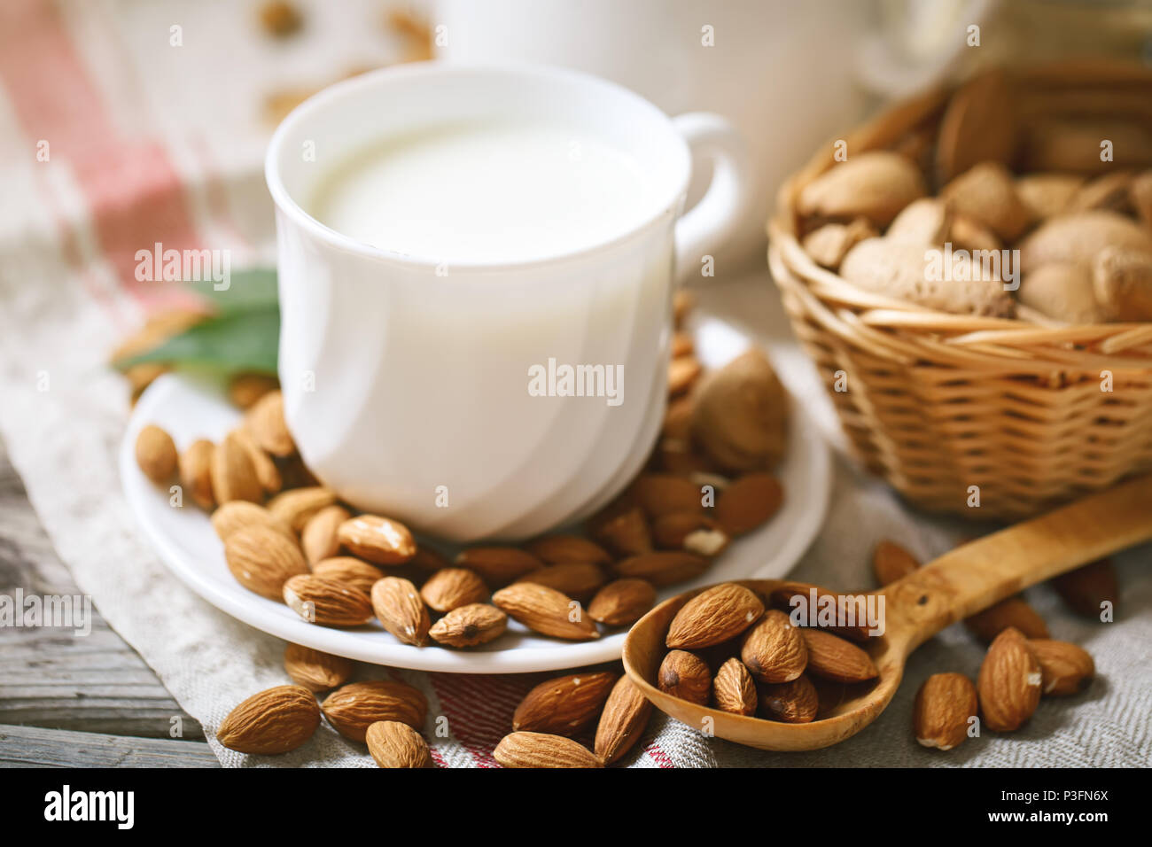 Almond and almond milk on a wooden table in the summer garden. Useful food. Stock Photo
