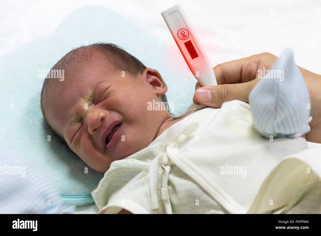 Asian cute new born baby check temperature with digital thermometer on