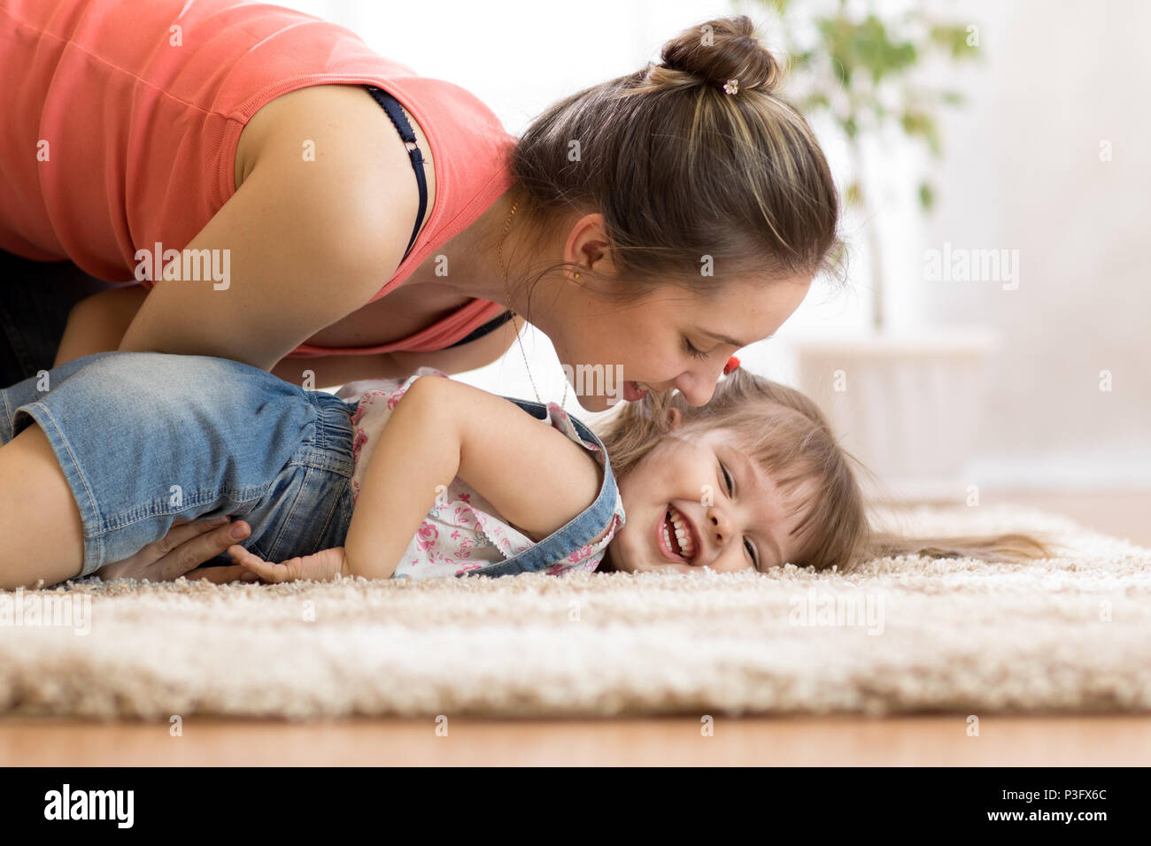 Love and family people concept - happy mom and child daughter having a fun at home Stock Photo