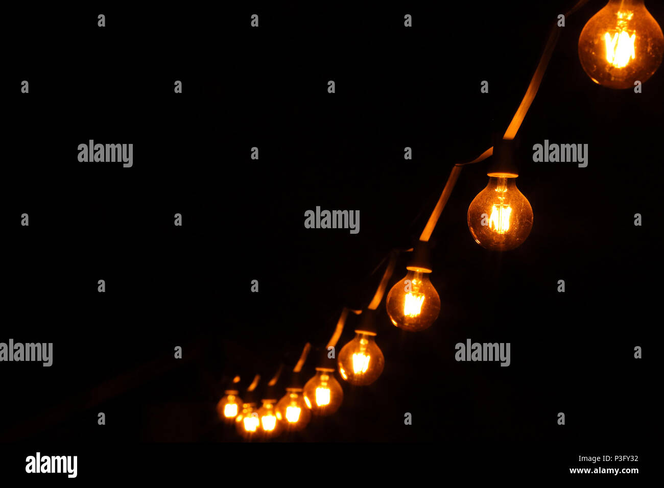 Decorative light bulbs on dark black background and empty space for text Stock Photo