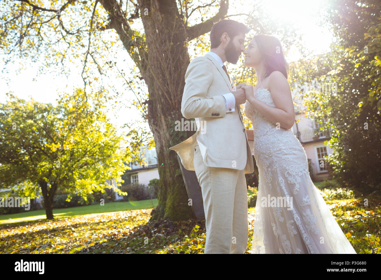 Bride and groom standing face to face in the garden Stock Photo