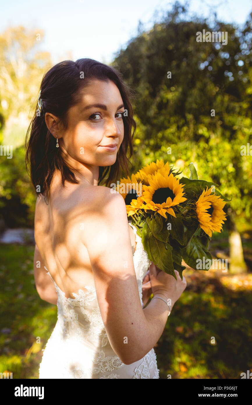Beautiful bride holding a sunflower bouquet in the garden Stock Photo