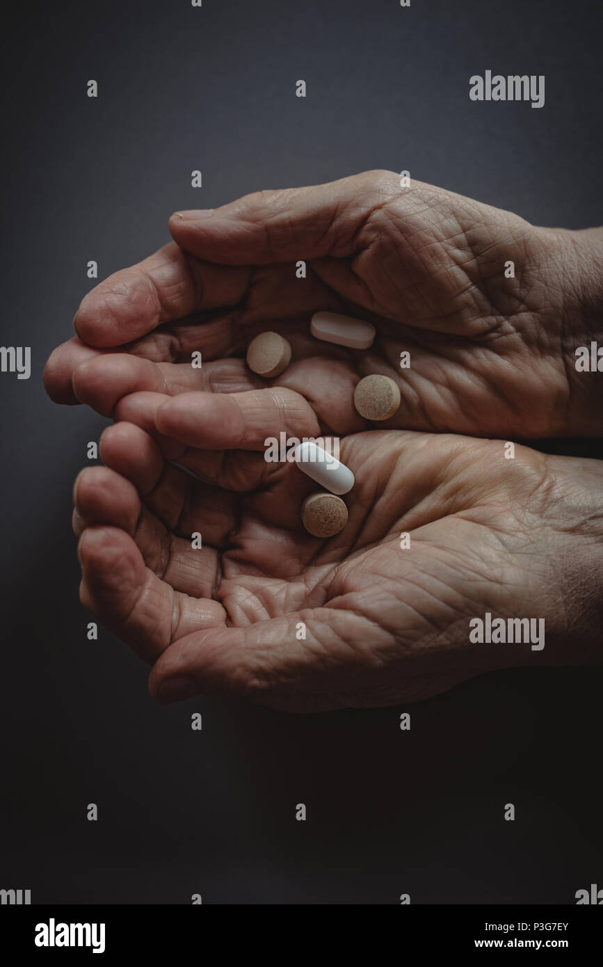 Senior womans cupped hands holding tablets Stock Photo
