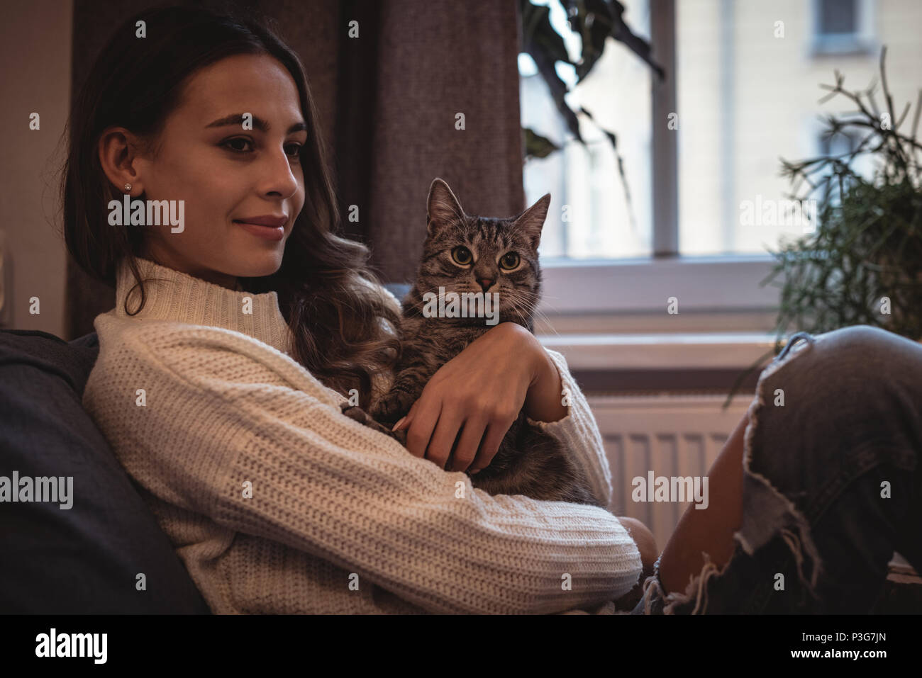Smiling woman sitting with her pet cat Stock Photo