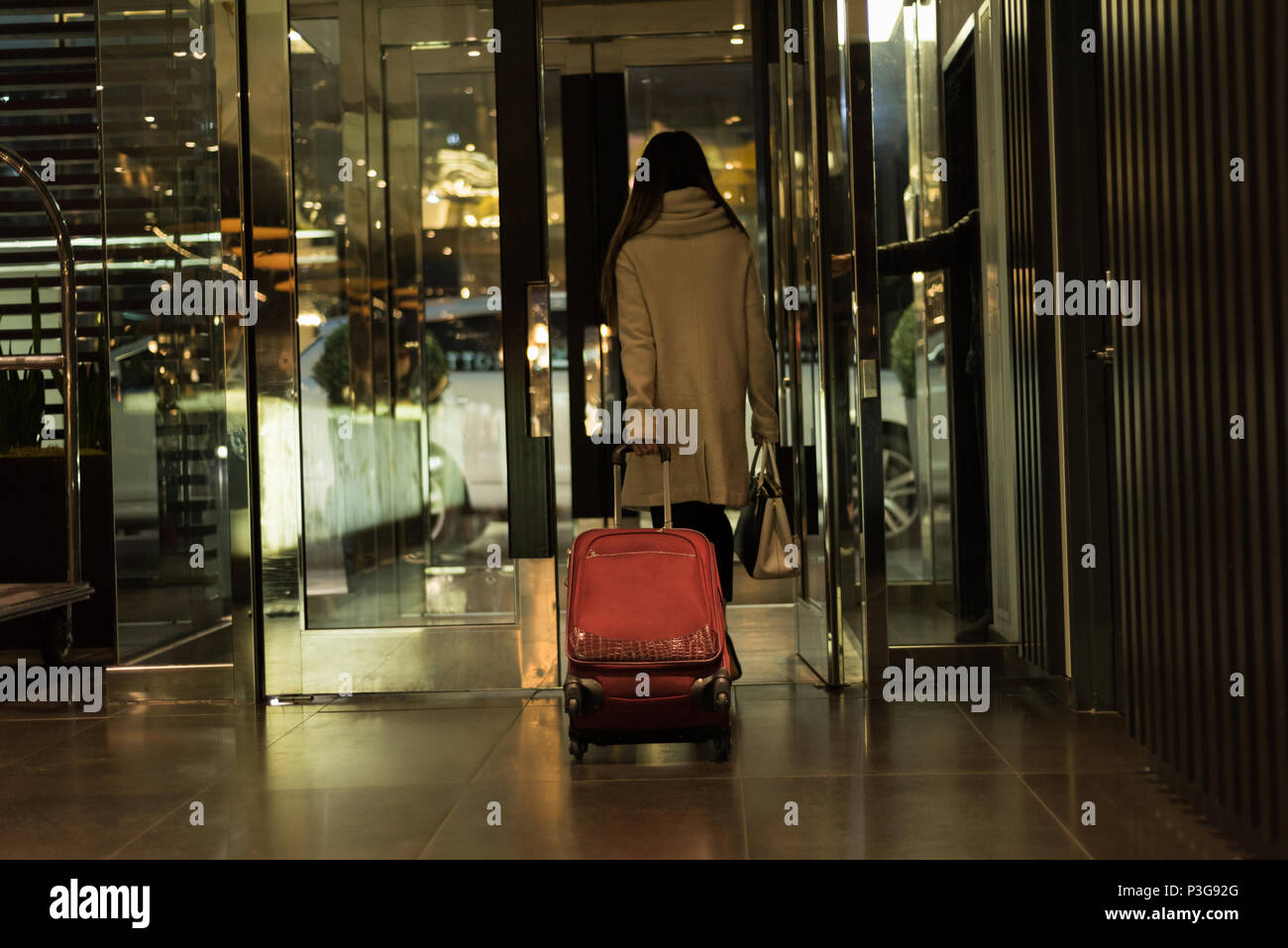 Businesswoman walking out of the hotel room with baggage Stock Photo
