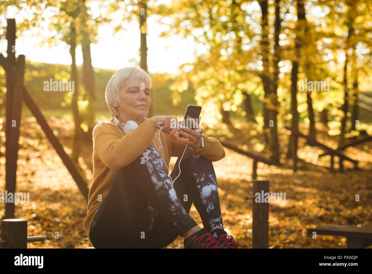 Senior woman using her mobile phone in the park Stock Photo