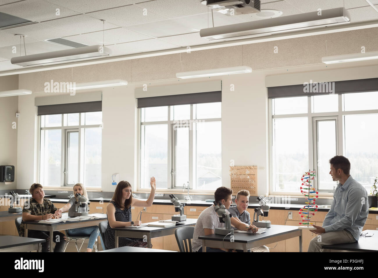 Teacher assisting students in experiment on molecule Stock Photo