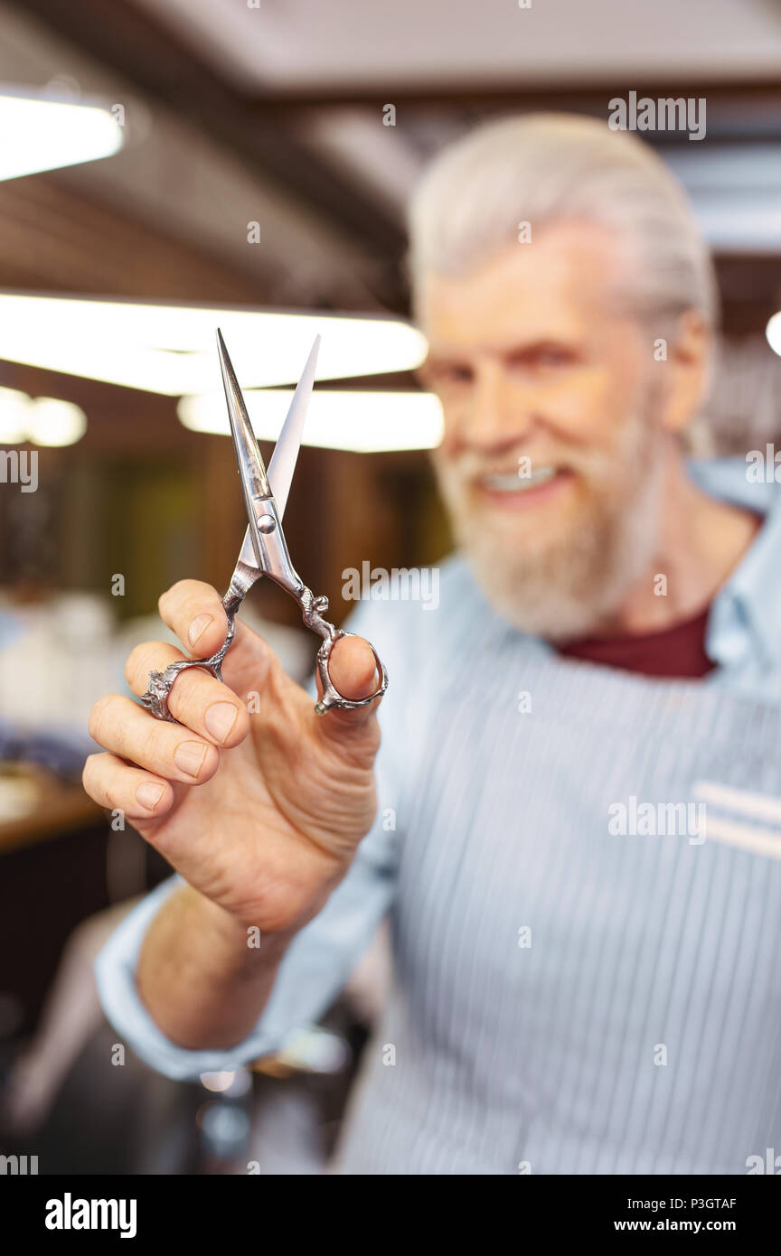 Focused photo on male hand that showing scissors Stock Photo