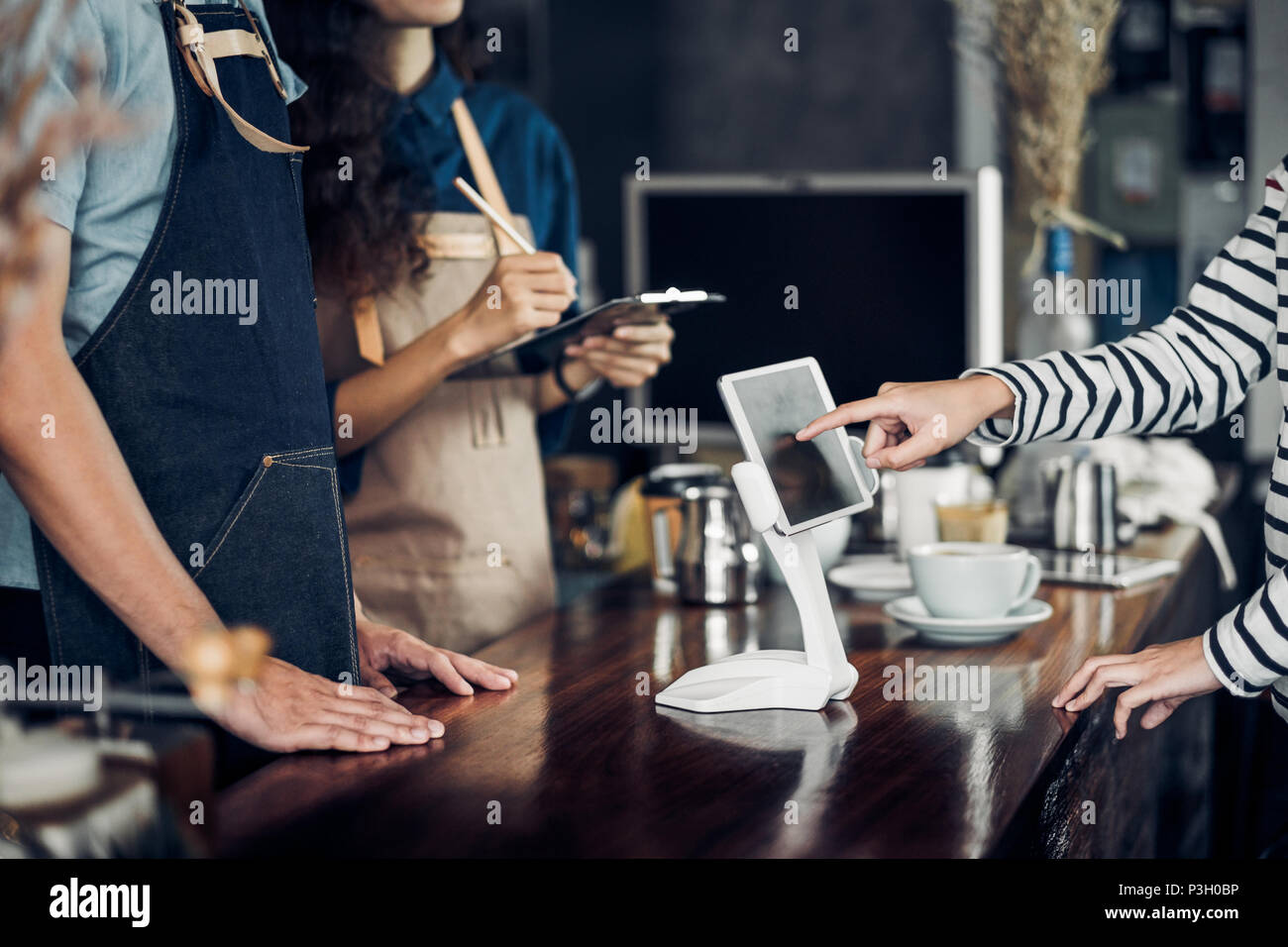 customer self service order drink menu with tablet screen at cafe counter bar,seller coffee shop accept payment by mobile.digital lifestyle concept.Bl Stock Photo