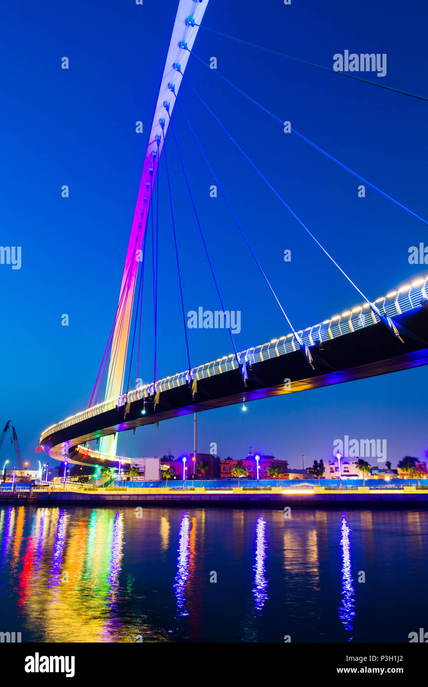 Dubai water canal bridge reflected in the water at night Stock Photo