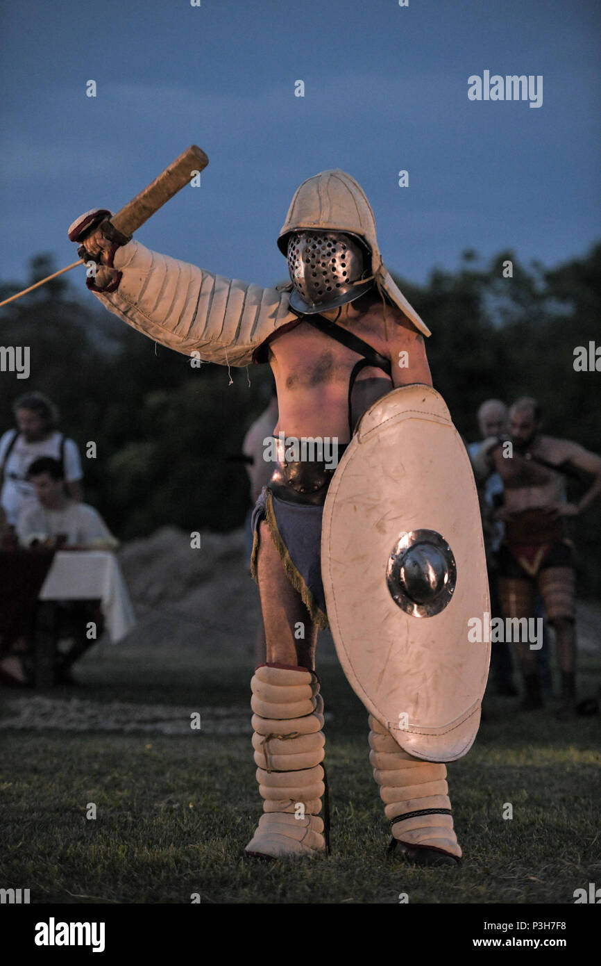 Aquileia, Italy. 17th June, 2018. A Gladiator wearing a traditional Ancient Roman costume poses with helmet shield and sword before a battle during Tempora in Aquileia, ancient Roman historical re-enactment Stock Photo