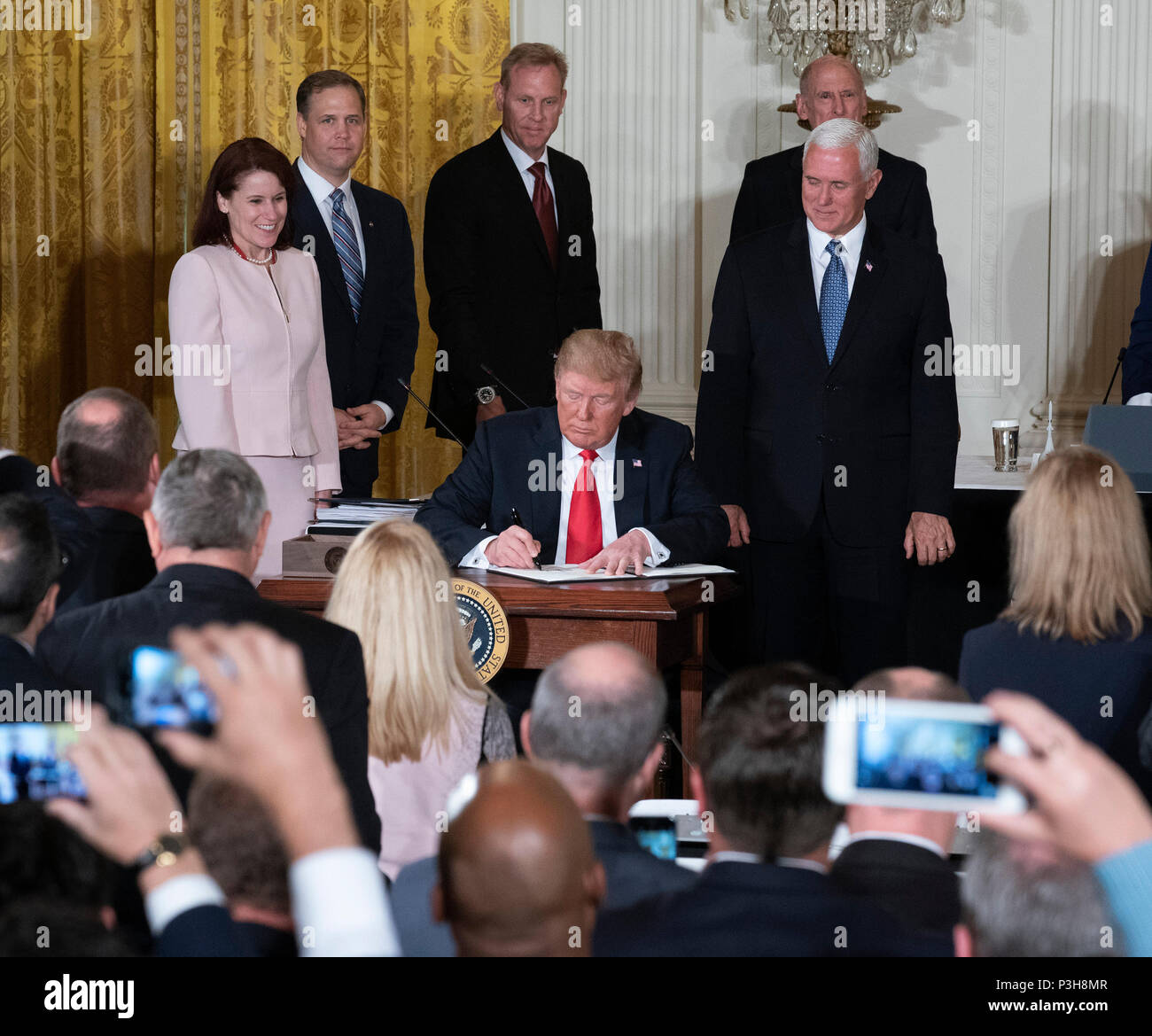 United States President Donald J. Trump signs Space Policy Directive 3 during a meeting of the National Space Council at The White House in Washington, DC, June 18, 2018. The directive addresses issues including monitoring of objects in orbit, providing that information to spacecraft operators to avoid collisions, and to limit the growth of orbital debris. Chris Kleponis/CNP /MediaPunch Stock Photo
