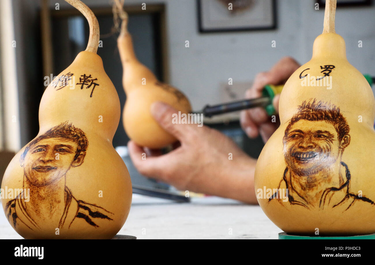 Zouchen, Zouchen, China. 18th June, 2018. Zoucheng, CHINA-18th June 2018: The folk artist Liu Yongjun makes gourd pyrography handicrafts in Zoucheng, east China's Shandong Province, marking the ongoing World Cup 2018. The portraits of famous football stars including Lionel Messi, Neymar da Silva Santos JÃƒÂºnior and Cristiano Ronaldo can be seen on the gourds. Credit: SIPA Asia/ZUMA Wire/Alamy Live News Stock Photo