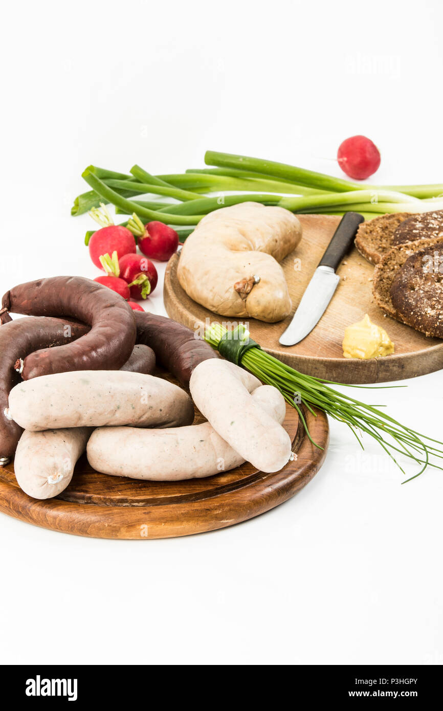 Leberwurst, Blutwurst, Frühlingszwiebeln, Radieschen, Schnittlauch, Senf und Brot auf weißem Hintergrund Stock Photo