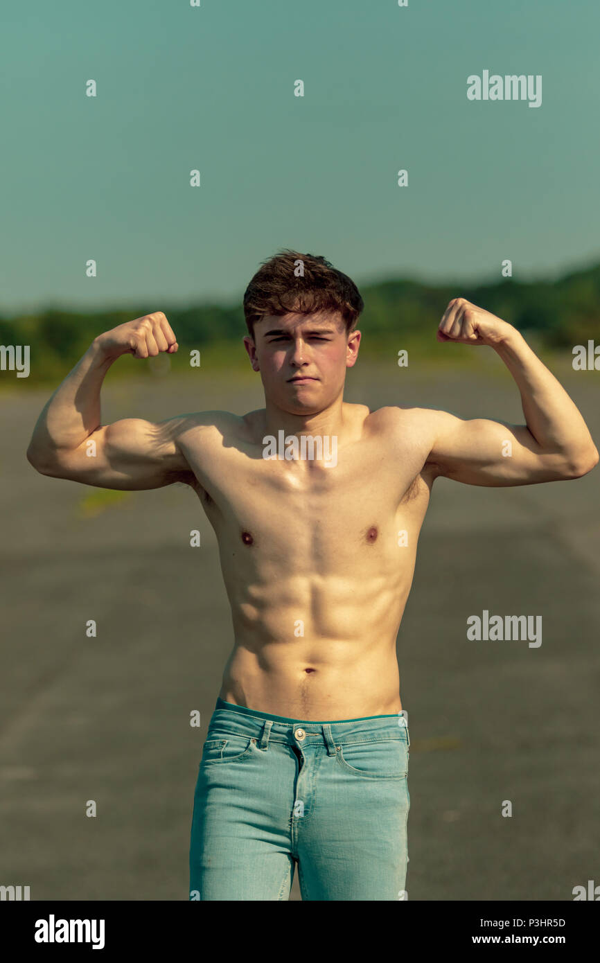 young-adult-male-flexing-his-muscles-on-a-warm-summer-s-day-stock-photo
