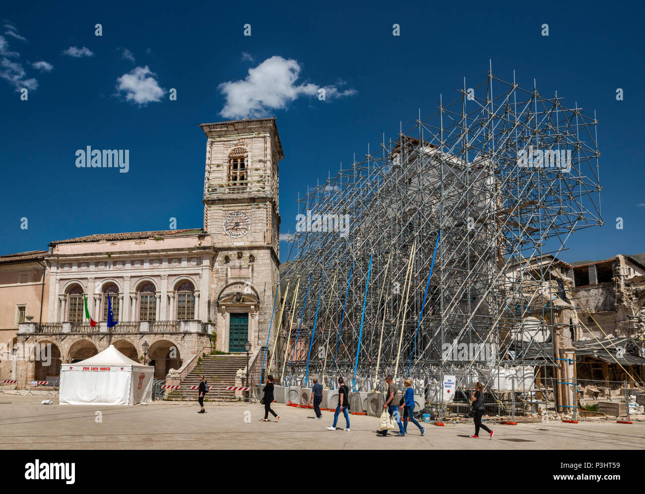 Palazzo Comunale, damaged, and facade, supported by scaffolding, of Basilica, destroyed by earthquakes, April 2018 view, in Norcia, Umbria, Italy Stock Photo