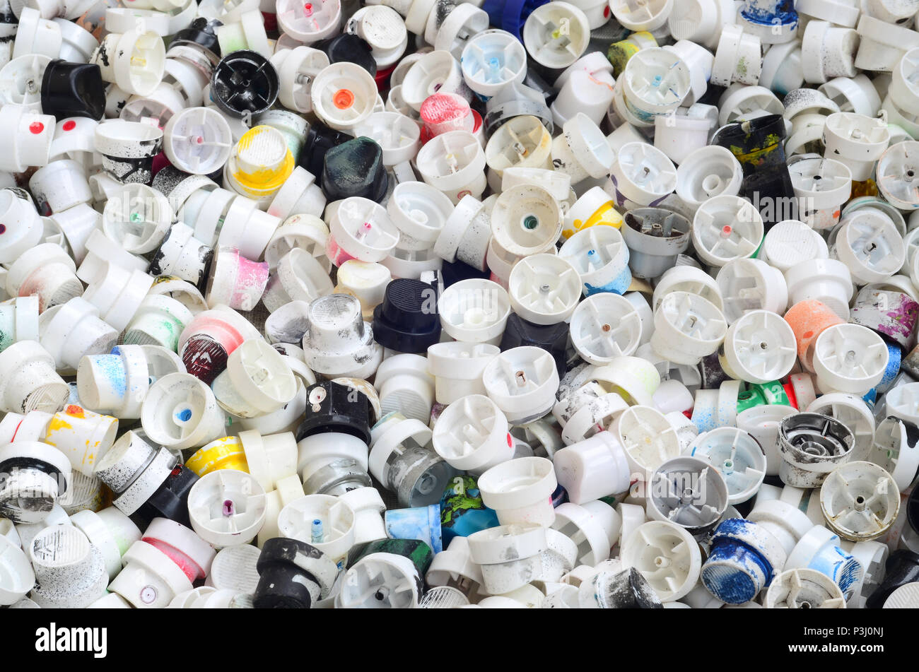 A pattern of many used and soiled nozzles from spray cans with aerosol