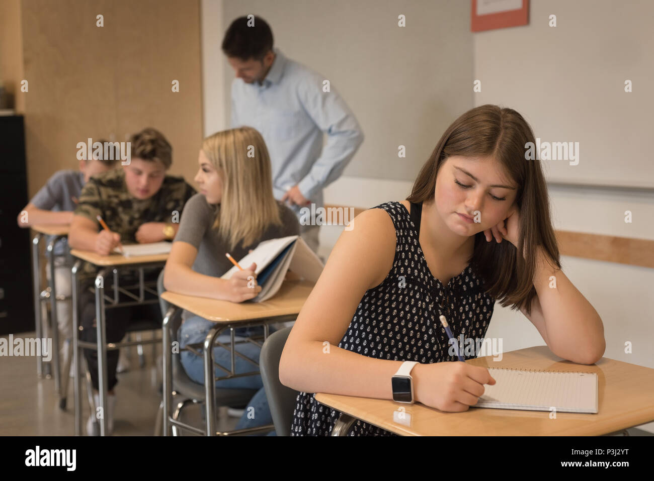 Thoughtful teenage girl sitting in classroom Stock Photo