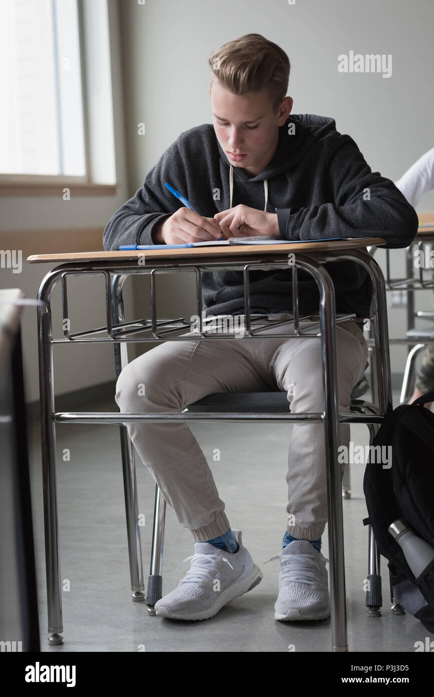 Teenage boy studying in classroom Stock Photo