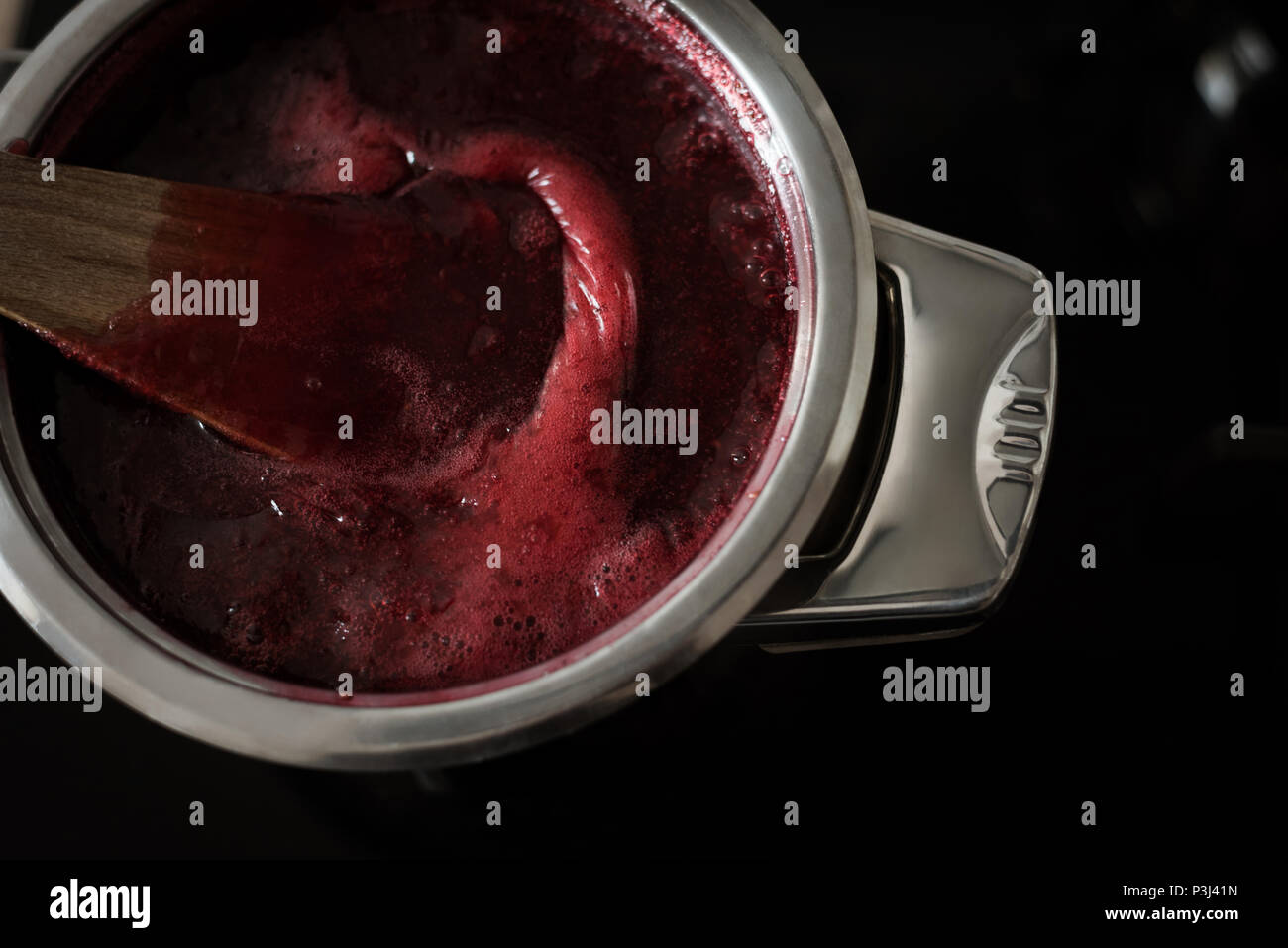 Raspberry jam in cooking vessel Stock Photo
