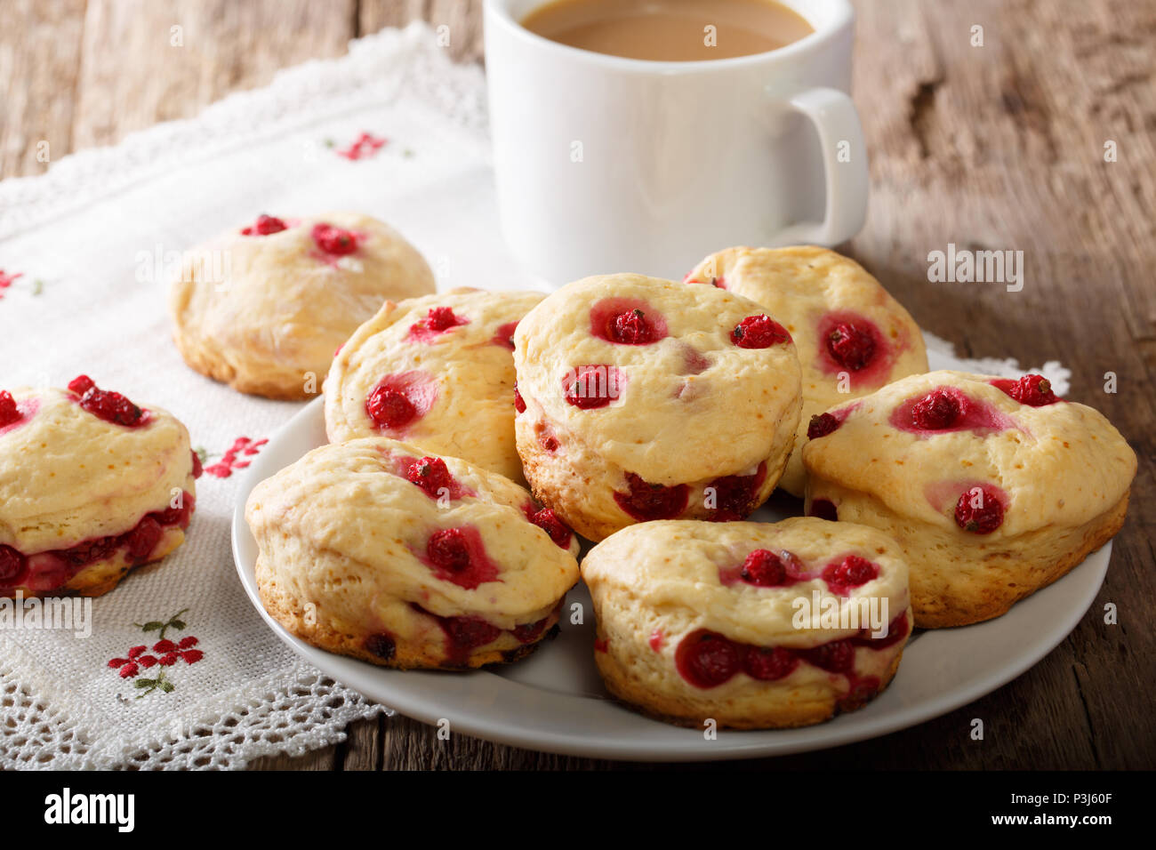 English sconces biscuits with red currants are served with tea and milk