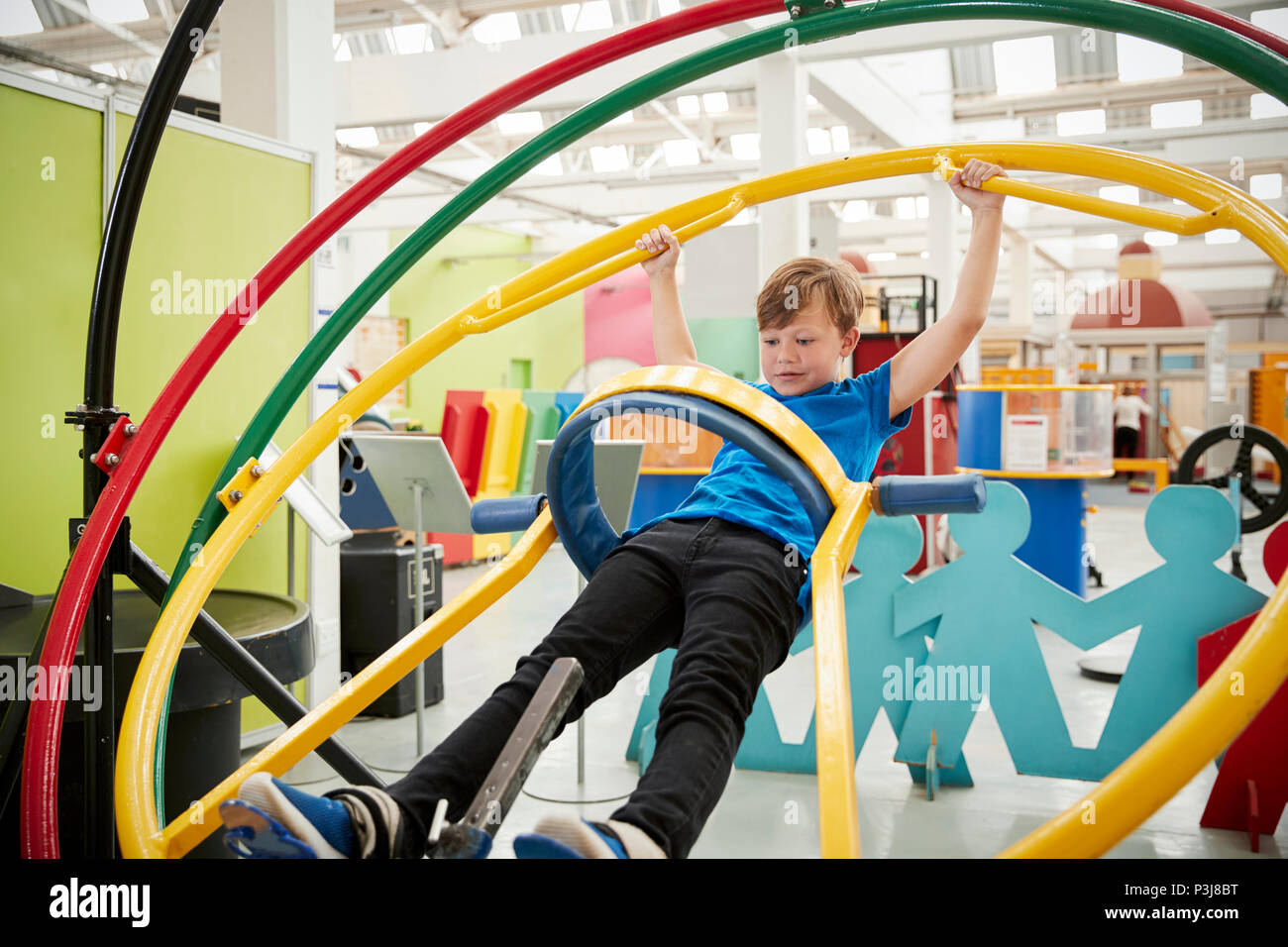 Young white boy in science centre using human gyroscope Stock Photo