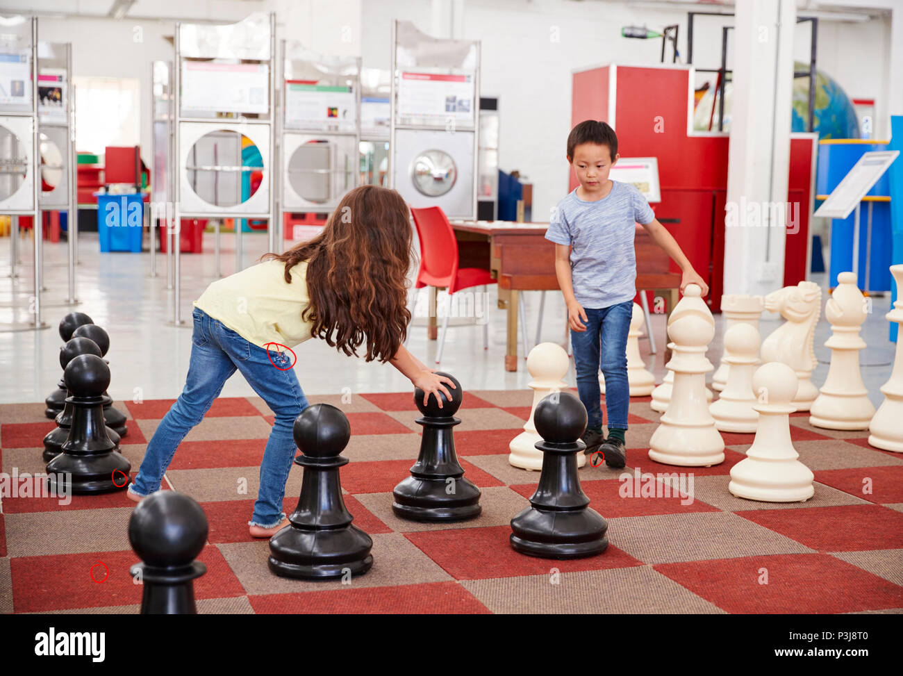Schoolchildren playing giant chess at a science centre Stock Photo