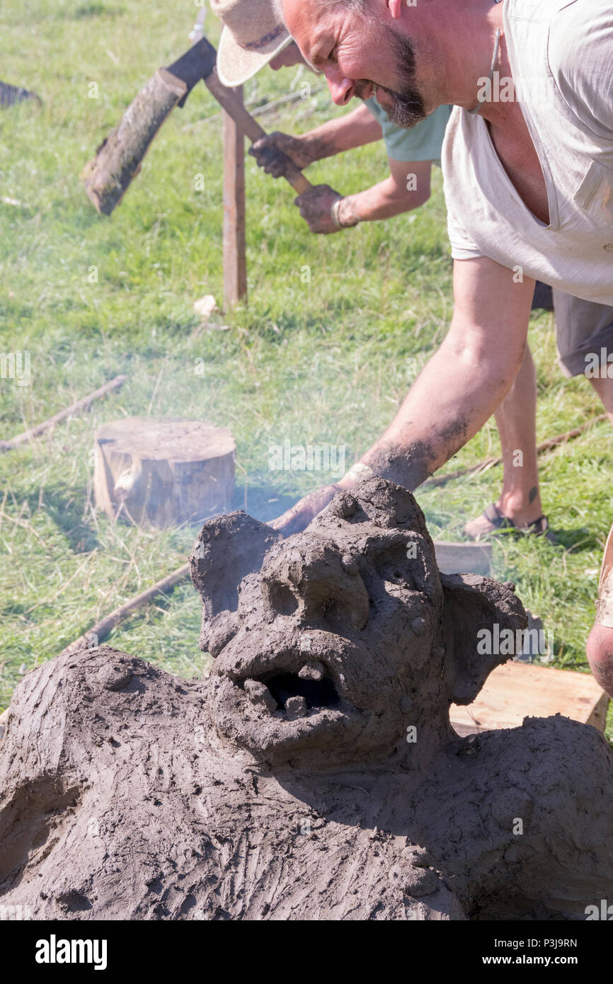 Chepstow, Wales – Aug 14: smoke comes from the mouth of a troll earth oven drying through first bake on 14 Aug 2016 at The Green Gathering Festival Stock Photo