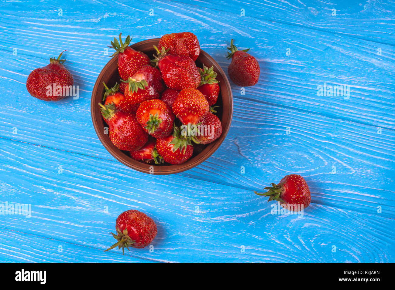Ripe red strawberries on a blue background with the top view Stock ...