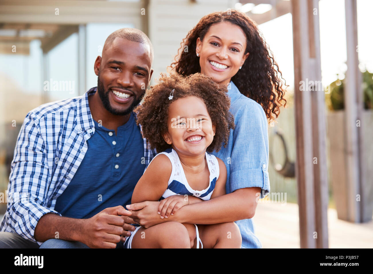 Young black family embracing outdoors and smiling at camera Stock Photo ...