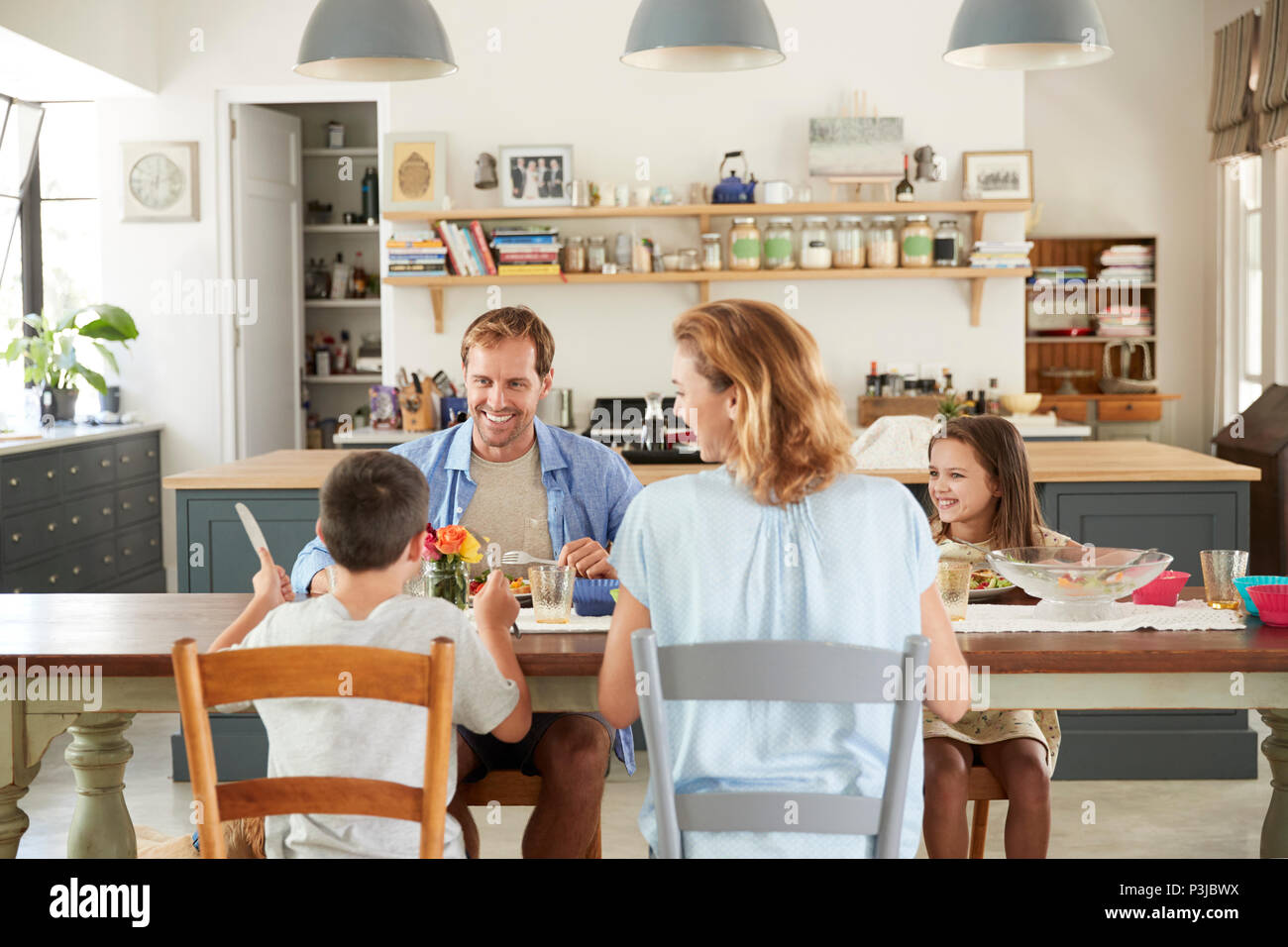 White family of four eating lunch in their kitchen at home Stock Photo