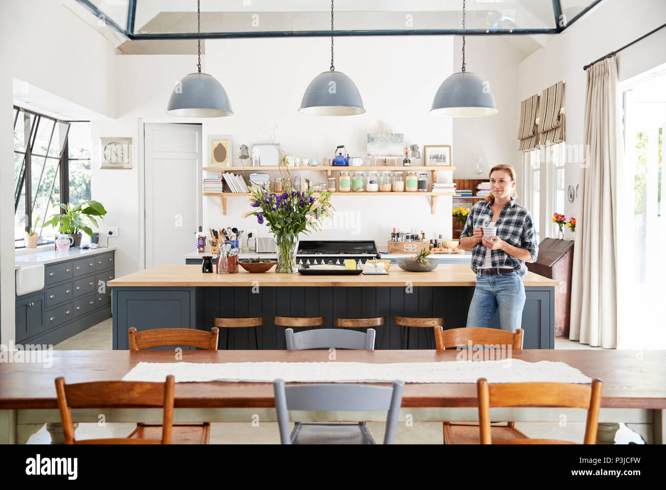 Young woman standing in an open plan kitchen dining room Stock Photo