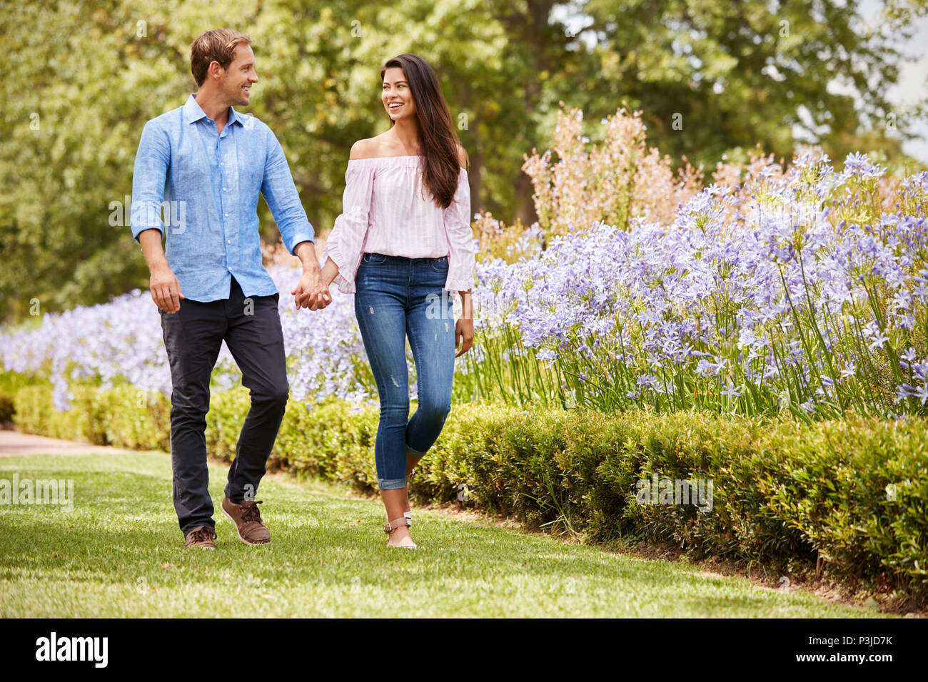 Couple Holding Hands On Romantic Walk In Park Together Stock Photo - Alamy