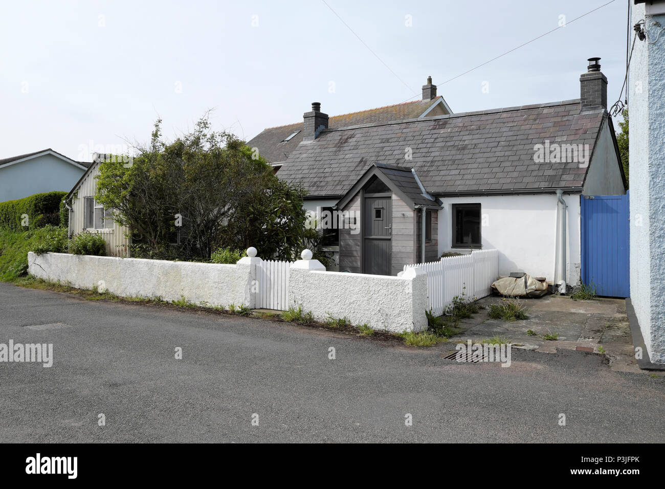 A small modernised cottage with a white stone wall and picket gate and fence in the village Marloes Pembrokeshire West WalesWales, UK  KATHY DEWITT Stock Photo
