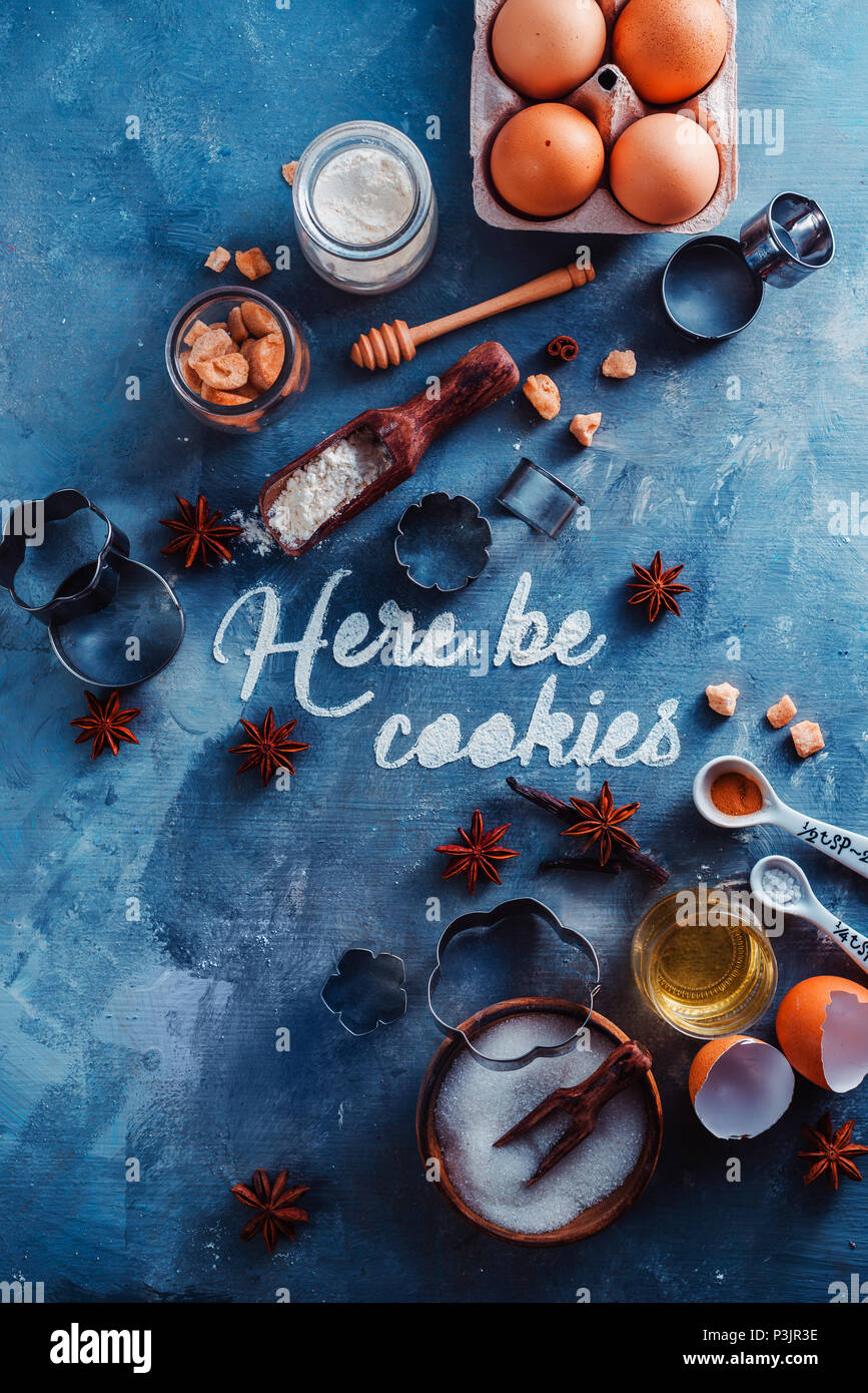 Pastry recipe concept from above with baking tools and ingredients. Food typography with Here be Cookies text on a marble table Stock Photo