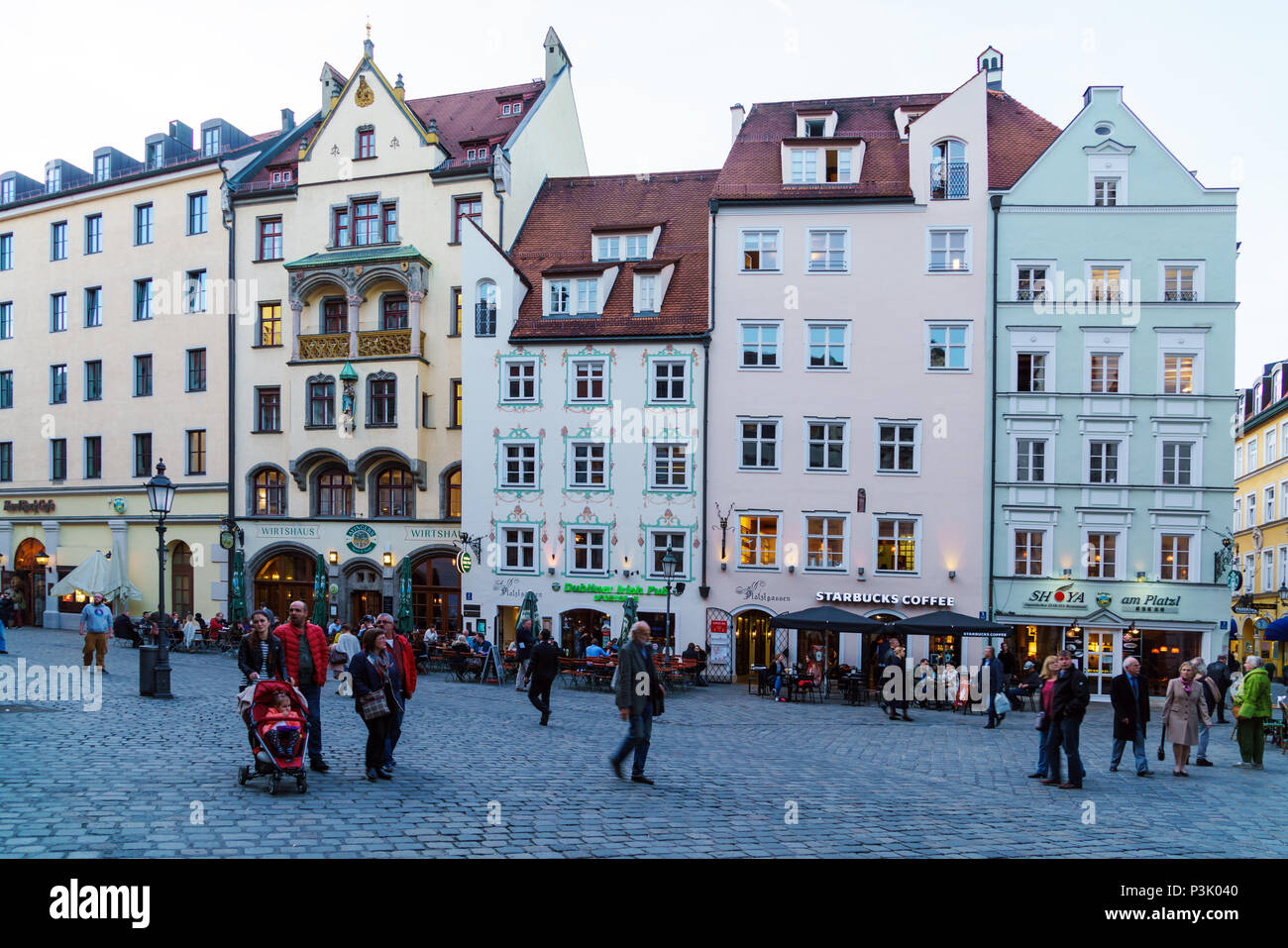 Munich, Germany - October 25, 2017:  Local residents walk through the streets of the old city next to the signs of beer restaurants Stock Photo